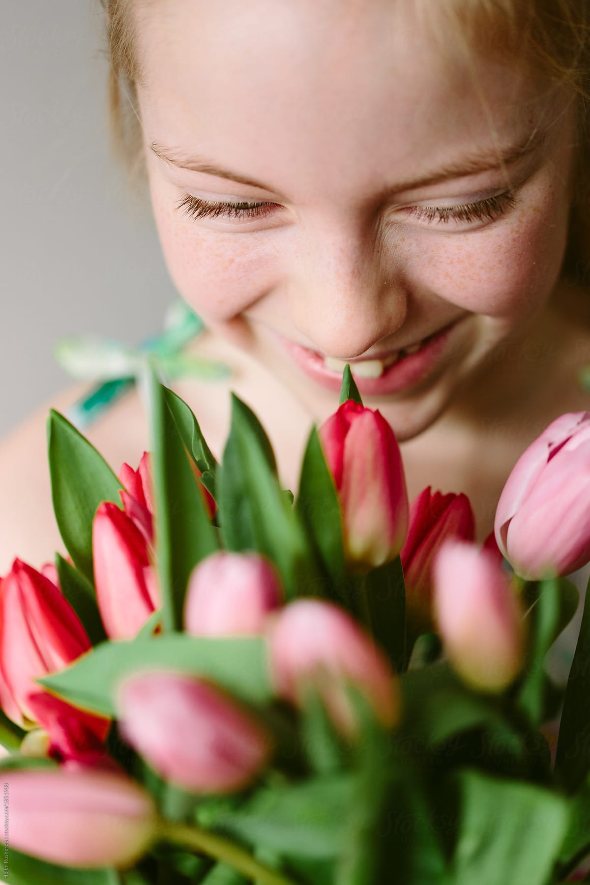 Smiling Preteen Girl Holding A Large Bouquet Of Spring Tulips By