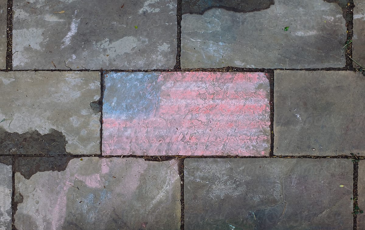 A washed out American Flag on a patio sidewalk.