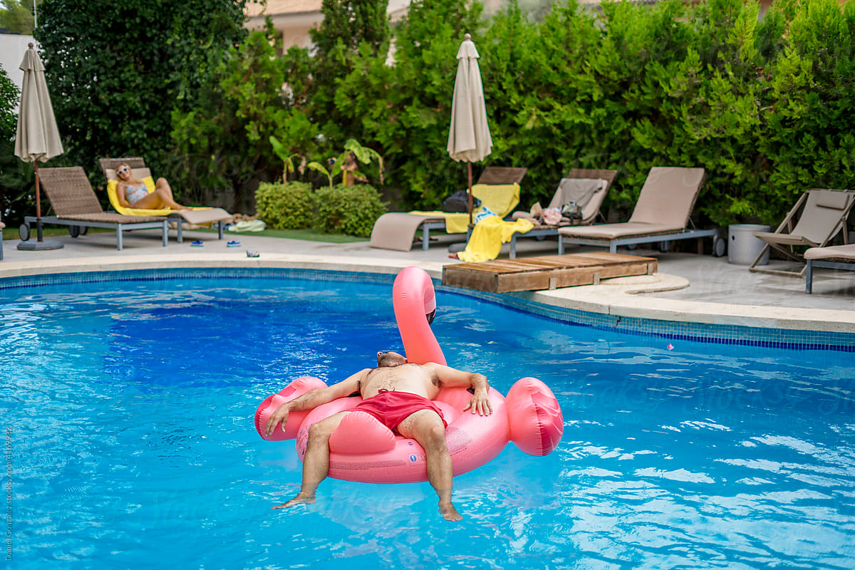 Traveler on inflatable flamingo in pool