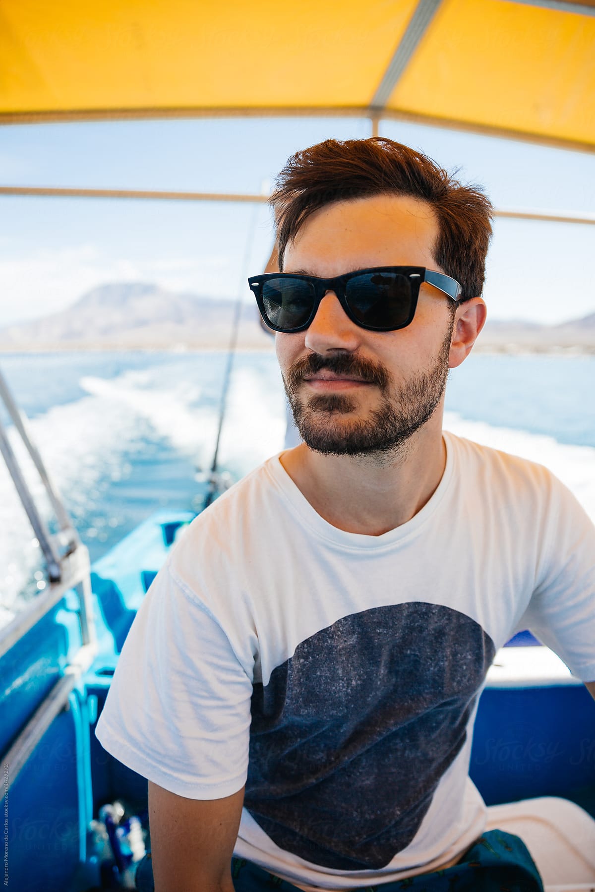 Good-looking bearded man in sunglasses on boat.