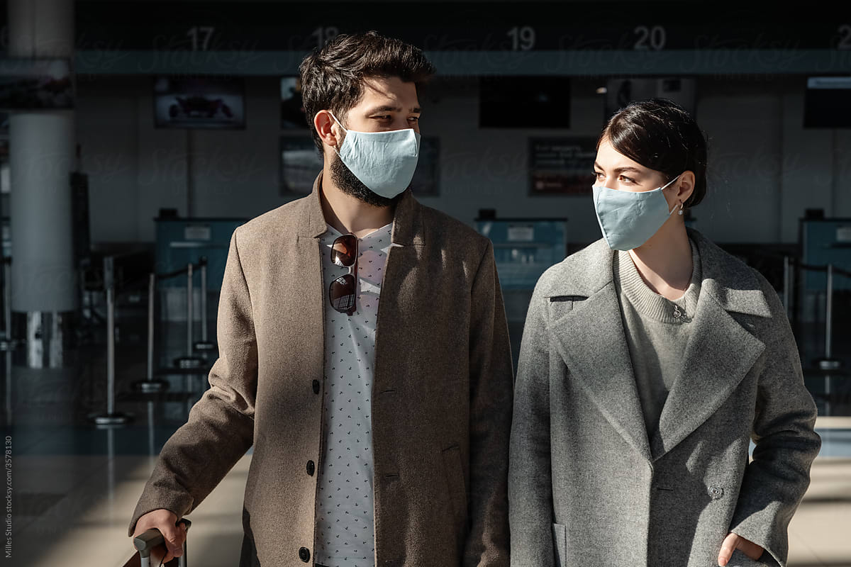 Man and woman in masks in airport terminal