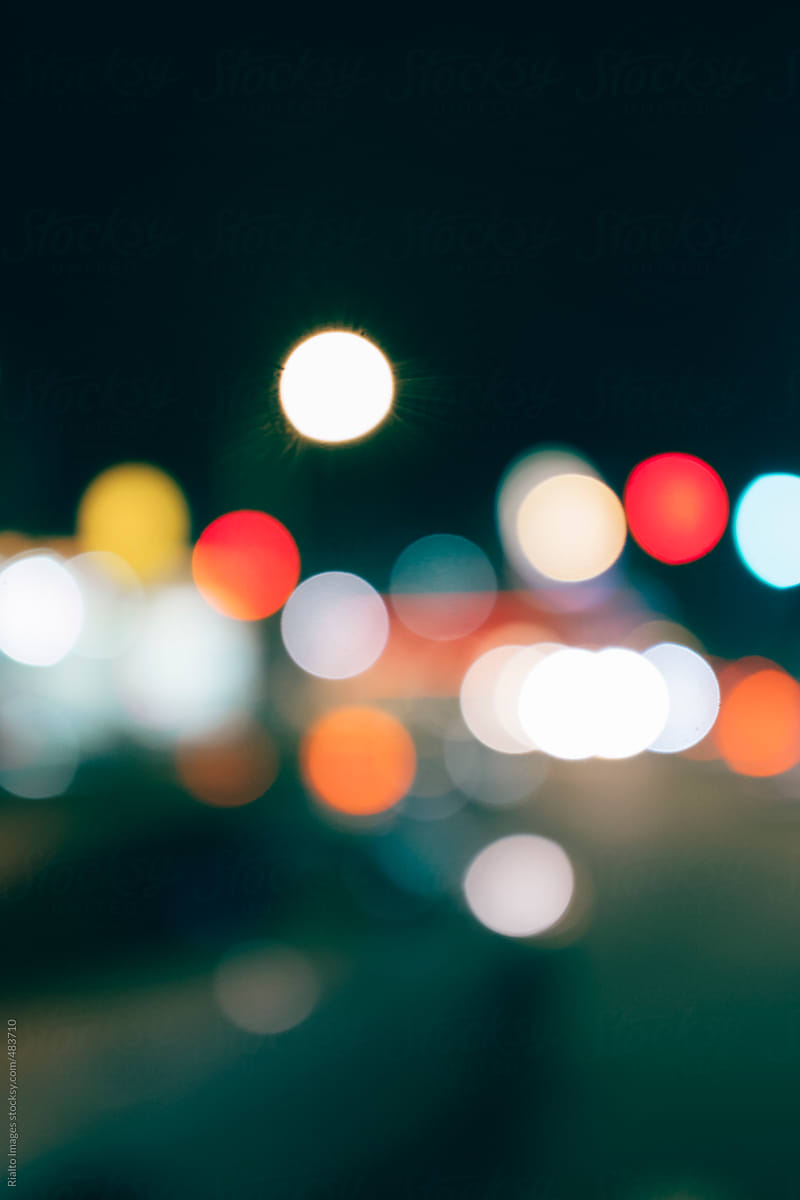 Car headlights and traffic lights at night, blurred focus