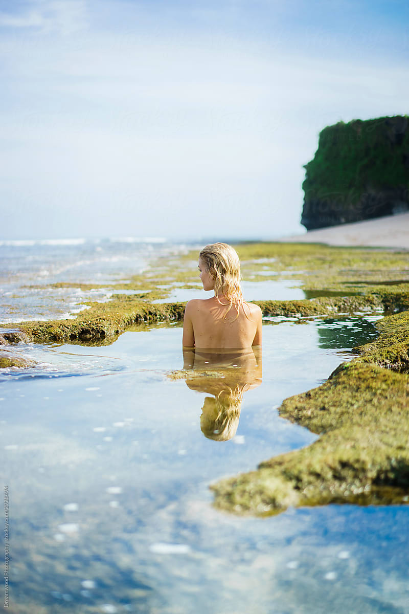 Blonde lady in swimsuit standing in deep pond