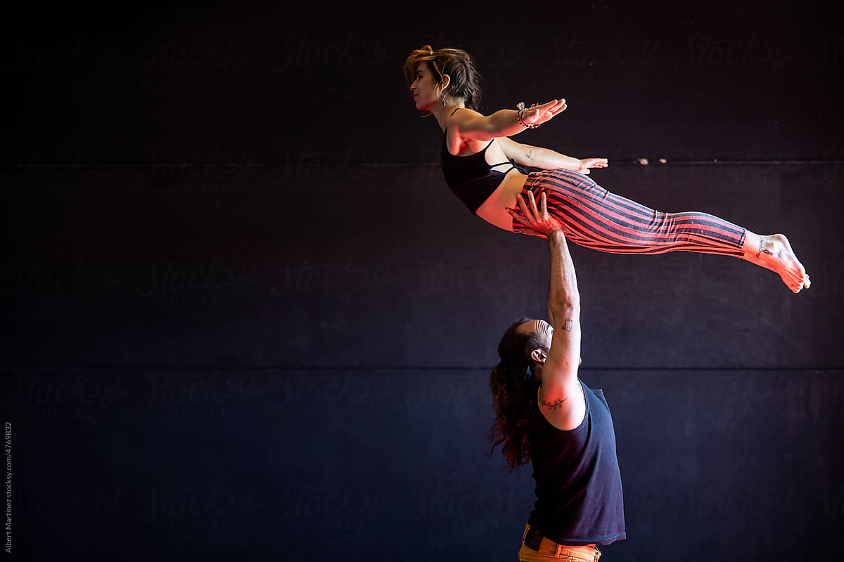 Skilled circus artist standing on partner shoulders