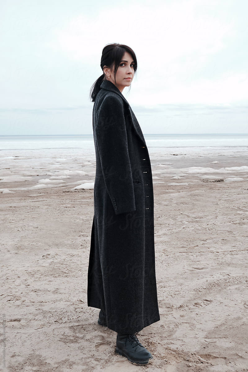 Woman in a coat on the winter seashore