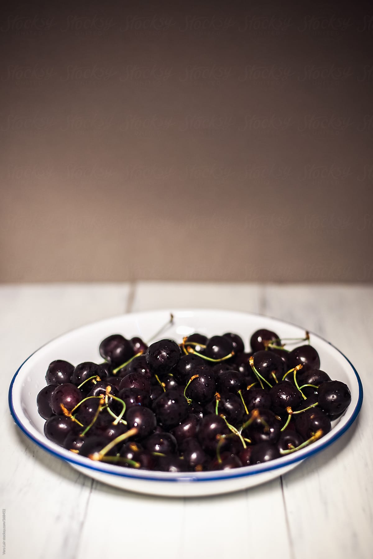 Black cherries on white plate