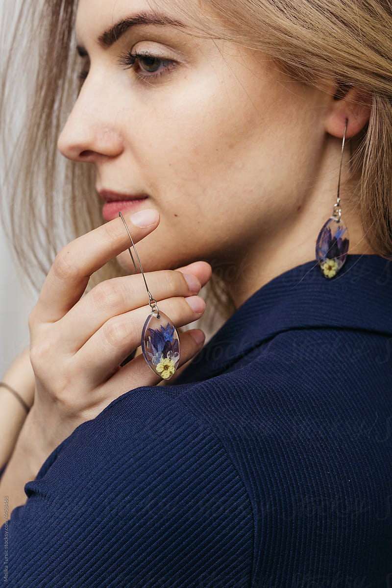 woman wearing floral epoxy earrings