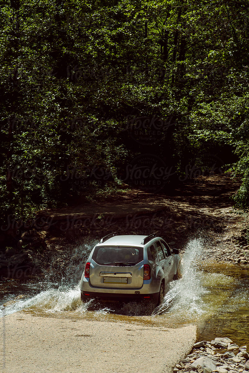 Car forcing the river in a mountain gorge