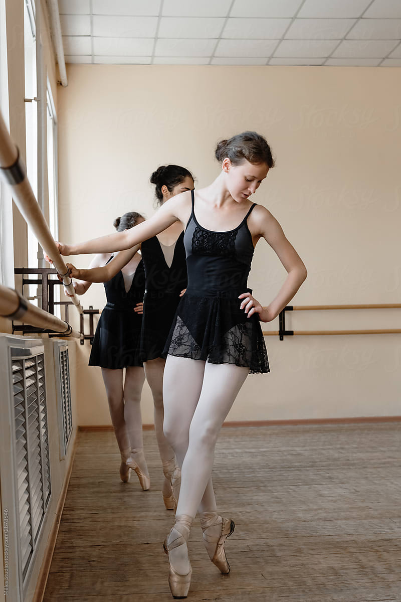 Young ballerina tiptoeing during group lesson
