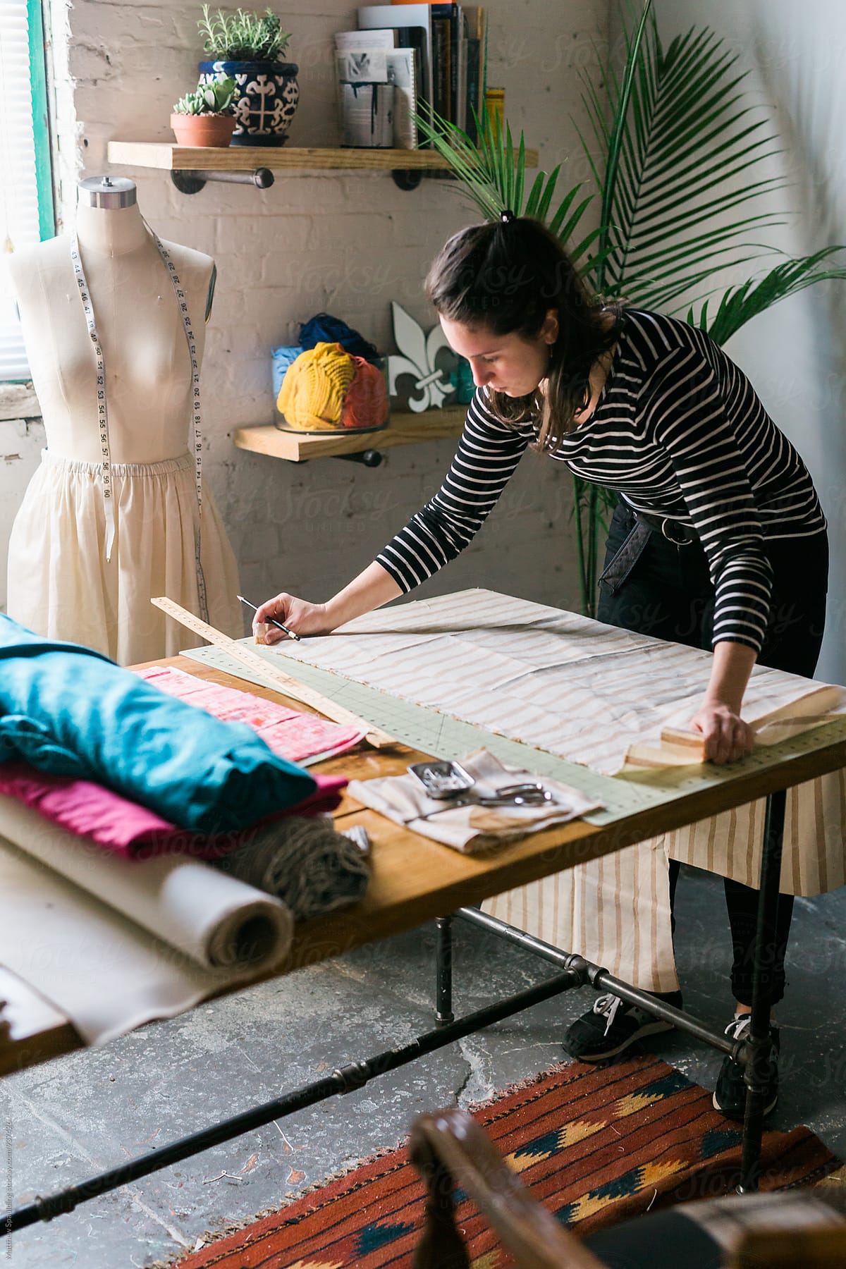 Designer measuring fabric for clothing pattern, vertical