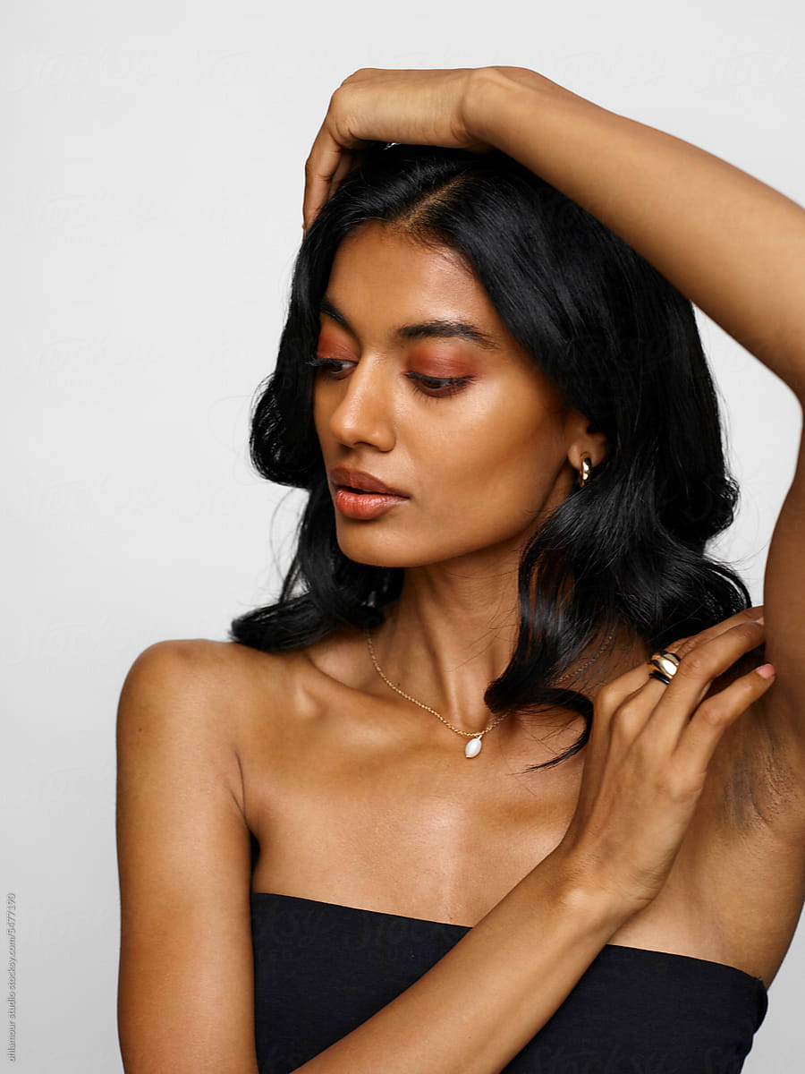 Elegant model wearing minimal black top and delicate jewelry