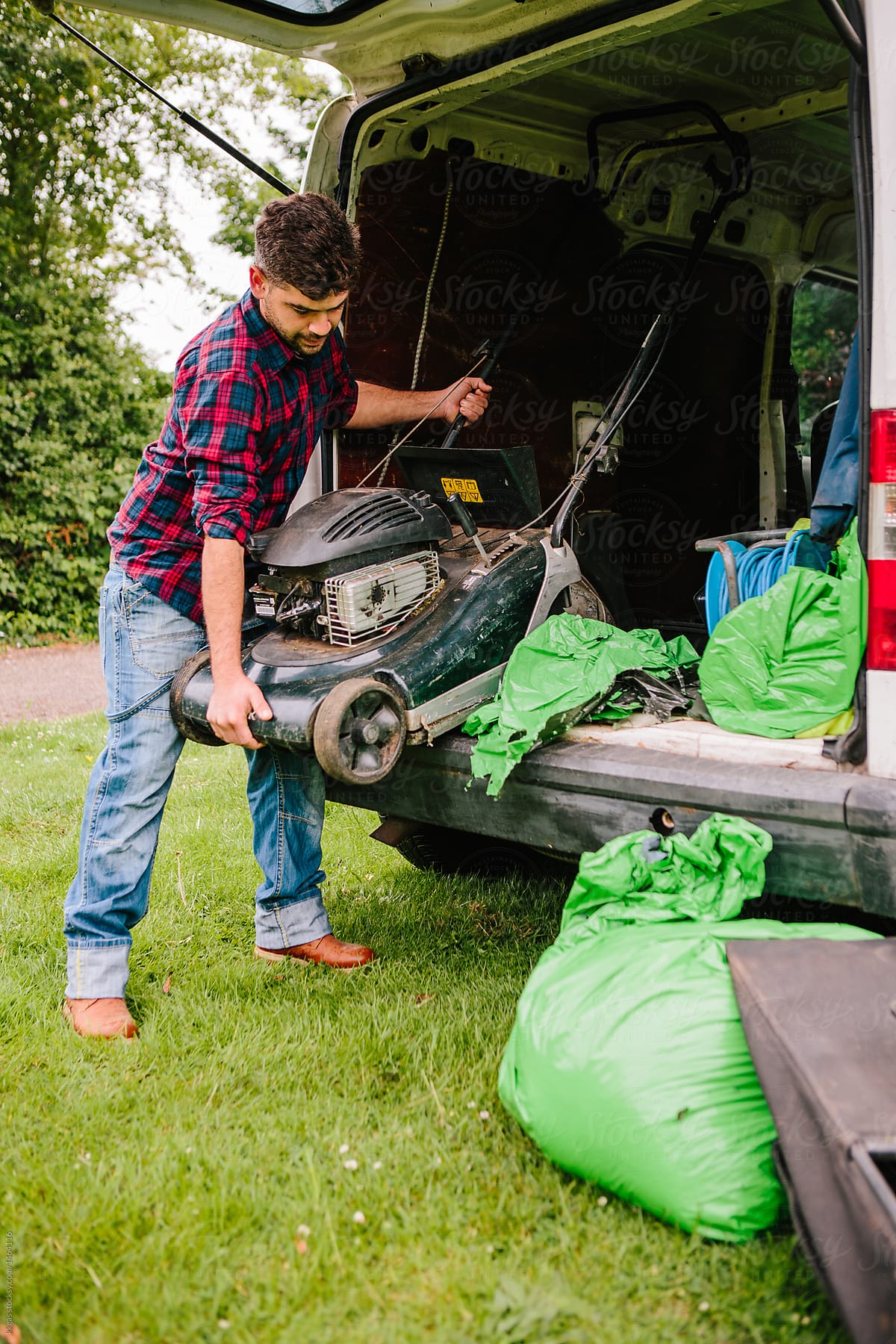 Professional gardener unloading a lawnmower from his van