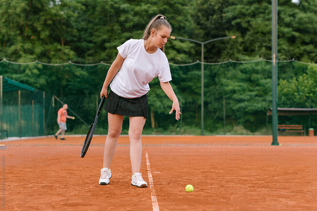 Young girl practicing tennis on the tennis court
