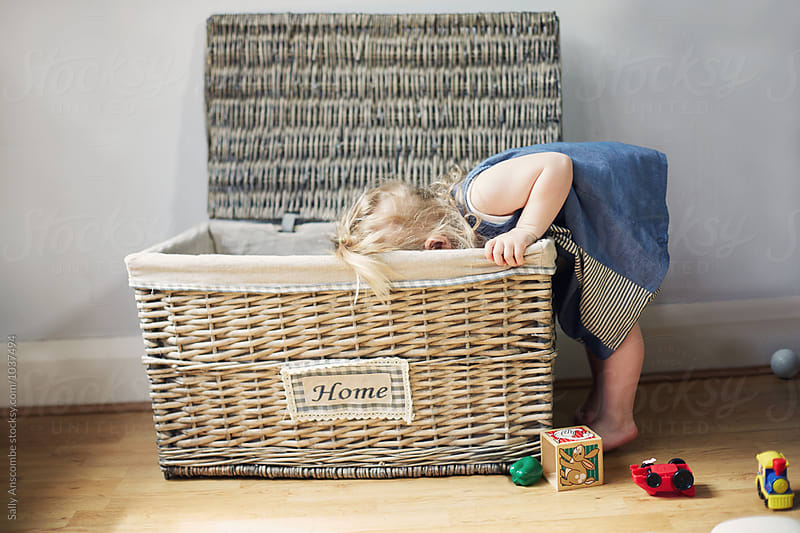 Child looking for toys in a toy box