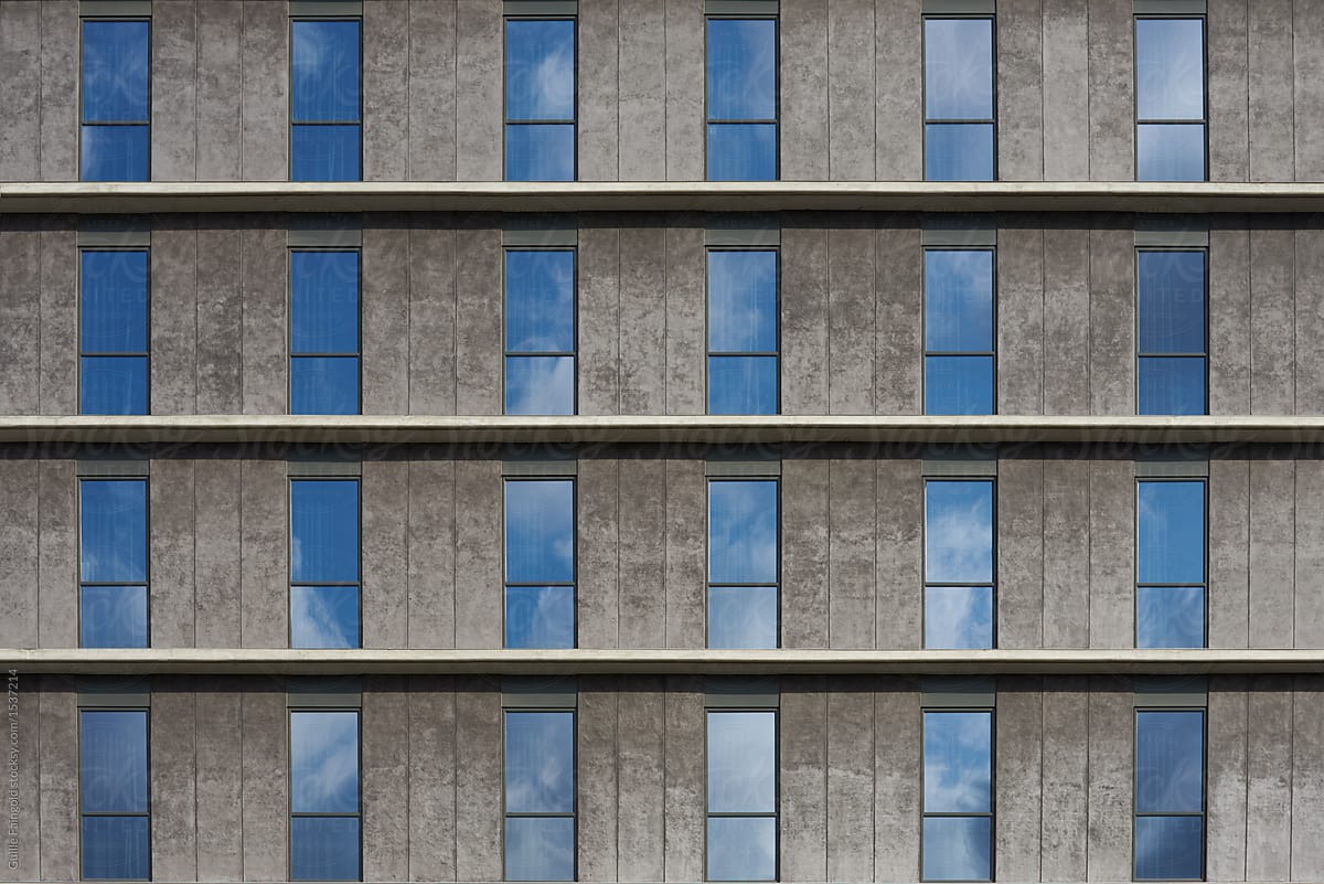 building facade with windows reflecting clouds.