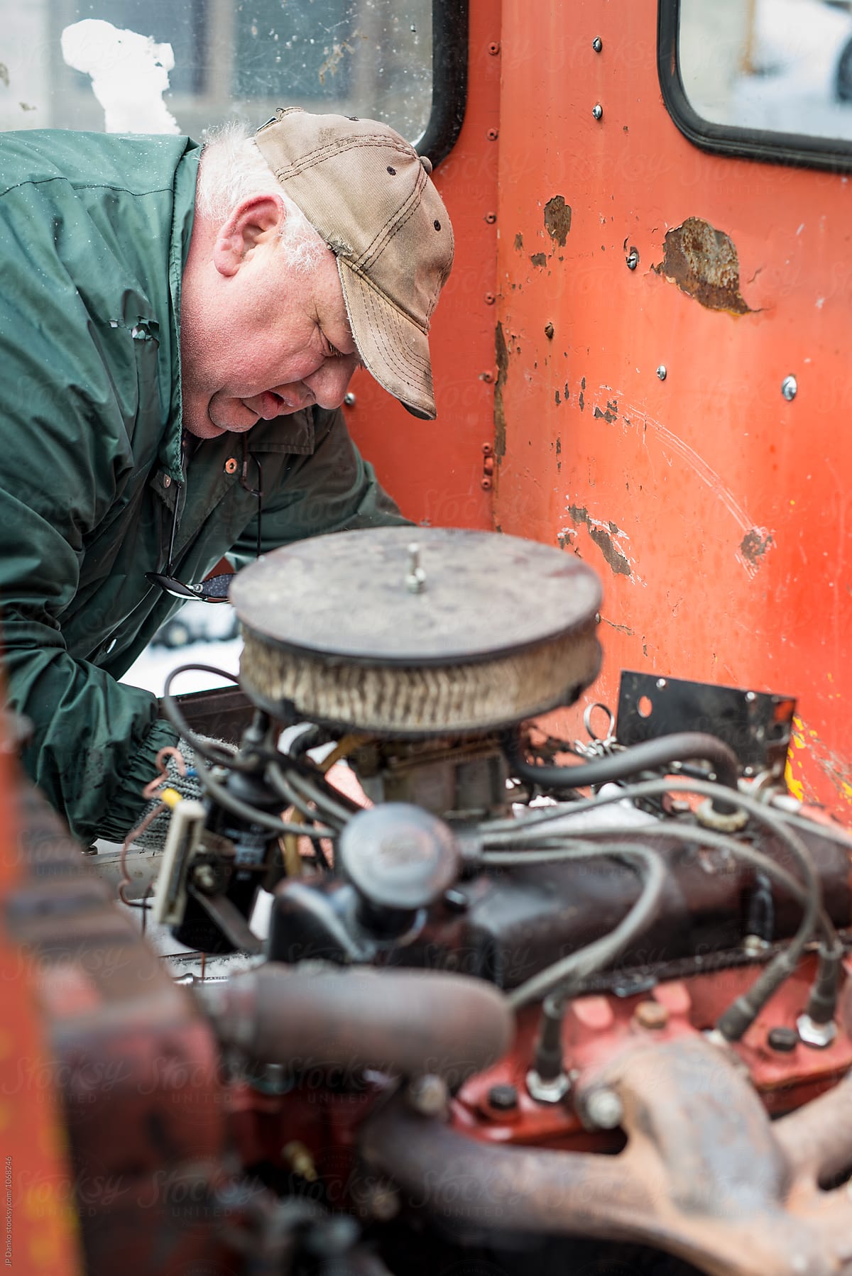 Man Auto Mechanic Farmer Repairing Old Engine on Rusty Farm Machenery