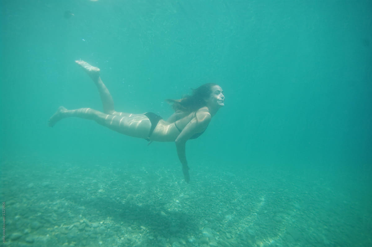 Young woman in bikini diving on breath hold
