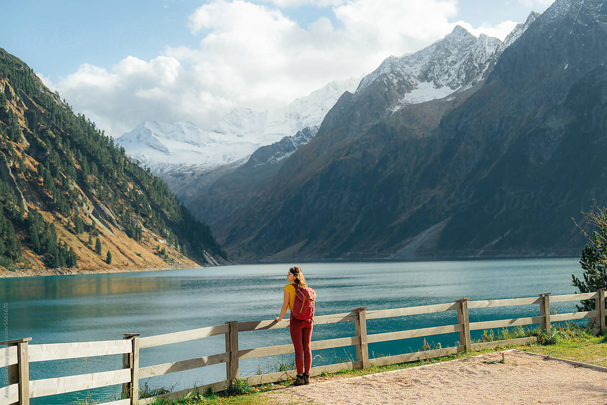 Woman standing on the background of the lake in Alps in autumn