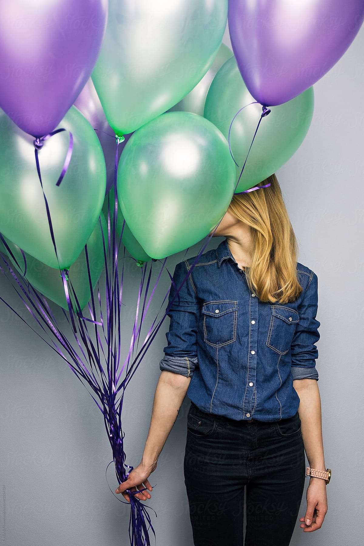 Woman closed face with balloons bunch
