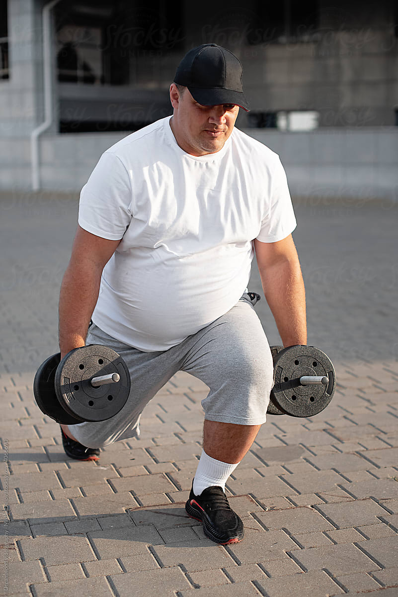 Man doing squats with dumbbells in his hands