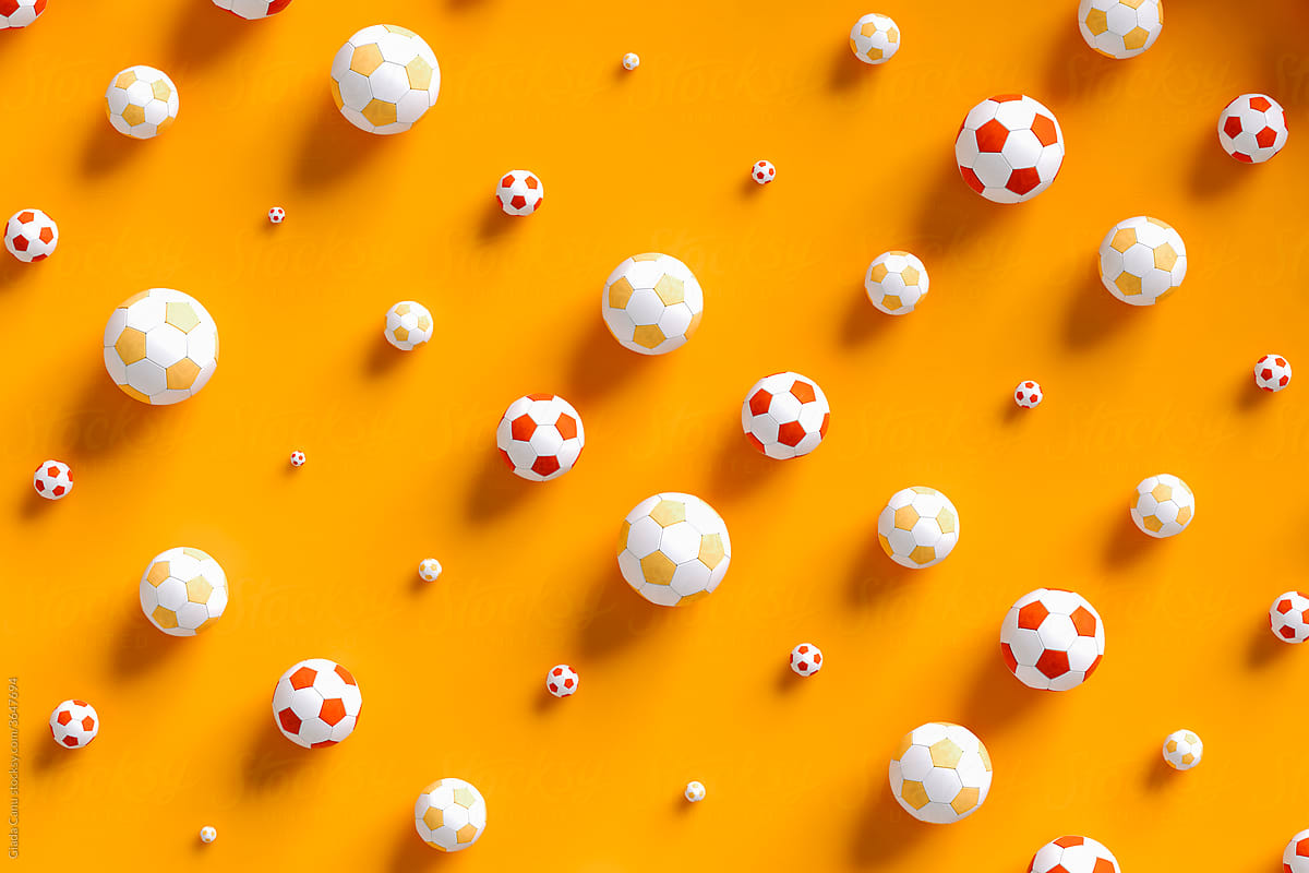 top view of some Soccer balls on orange background
