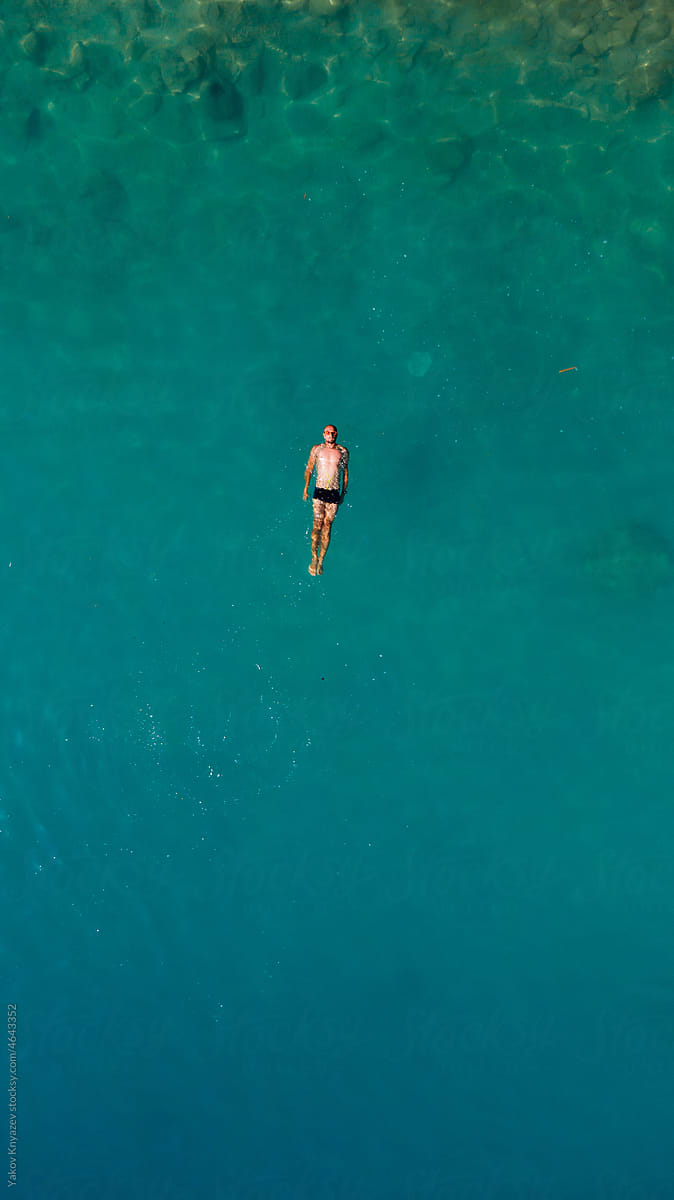young man floating in turquoise water