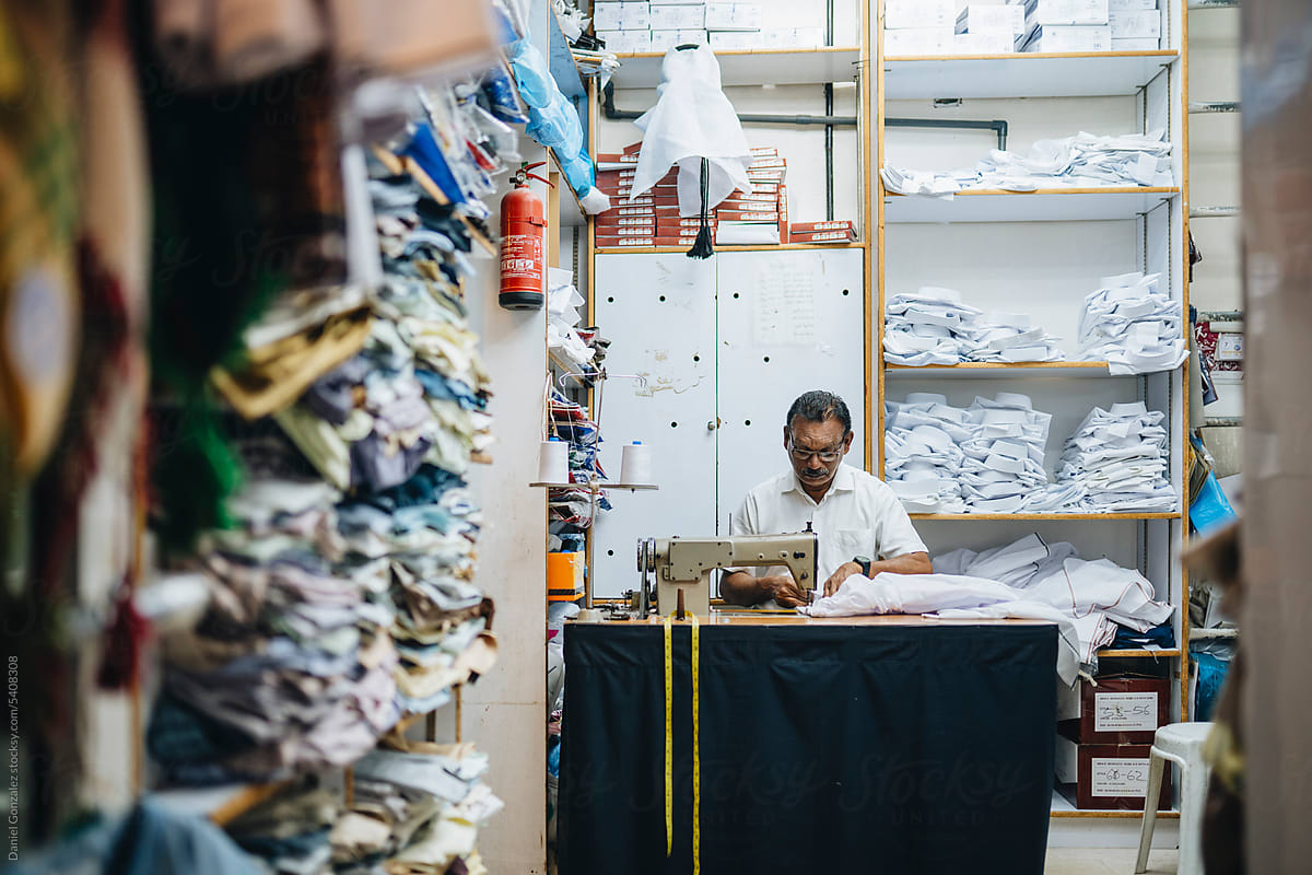 Serious Indian tailor creating new clothes in atelier