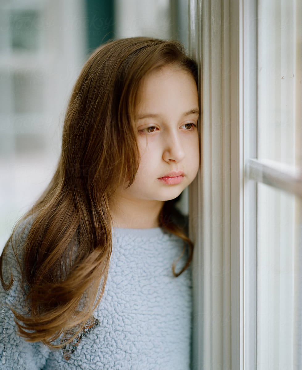 Young Girl Looking Sad And Bored Looking Out A Window By Jakob