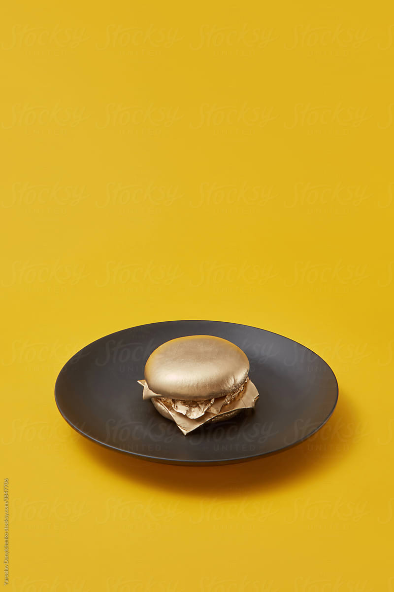 Golden burger on black plate