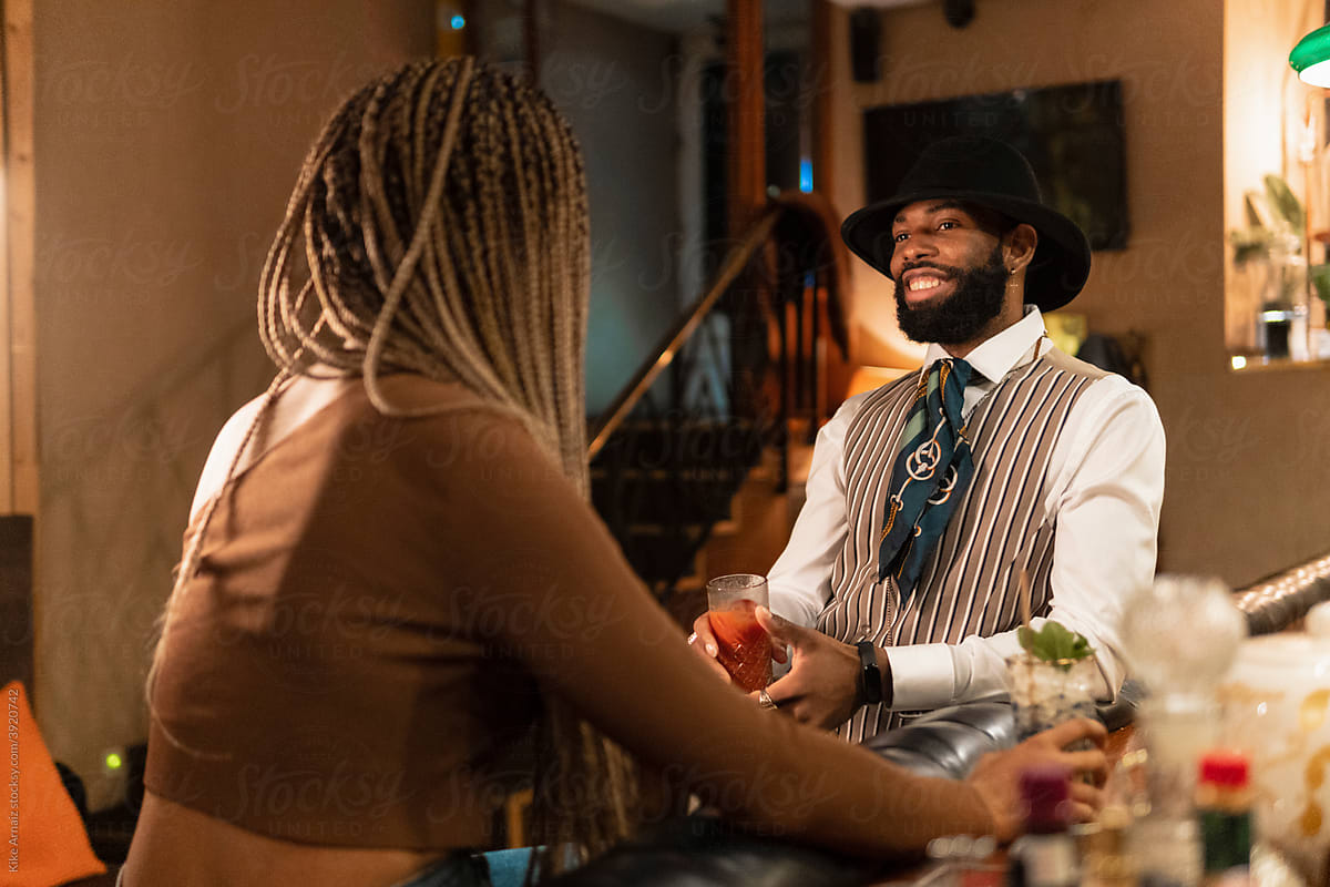 Cheerful black guy speaking with girlfriend in pub