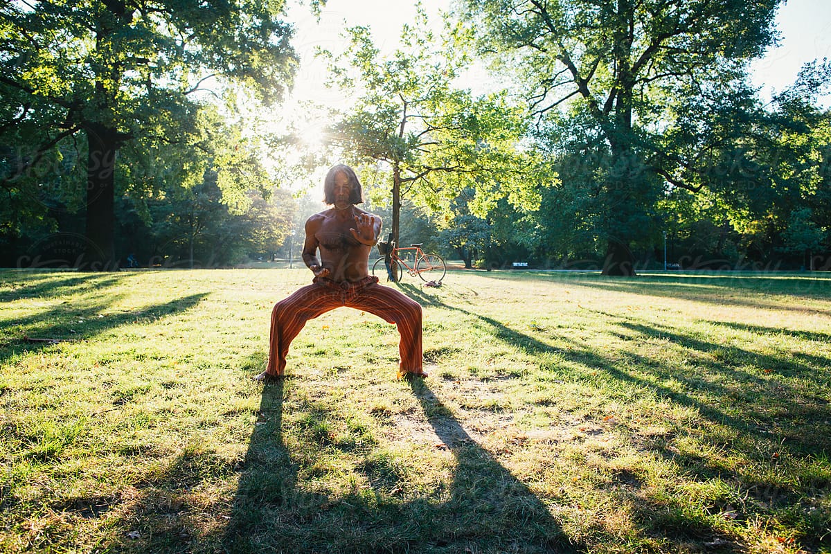 Fit Older Persian Man Practicing Chi Gung in Park in Warm Morning Light
