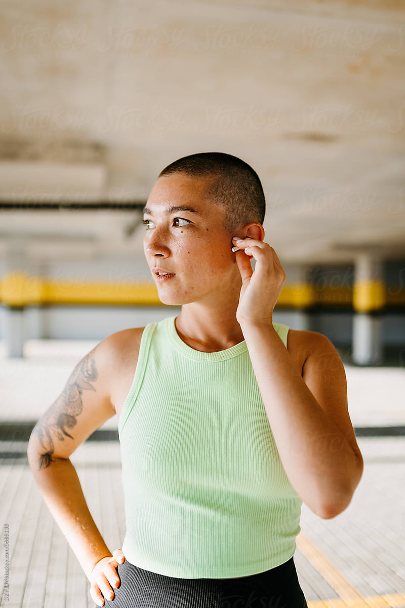 A woman inserts an earpiece into her ear
