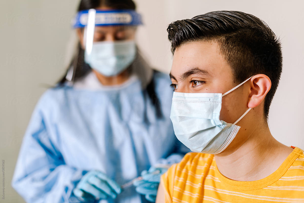 Hispanic teenager preparing for vaccination from coronavirus in hospital