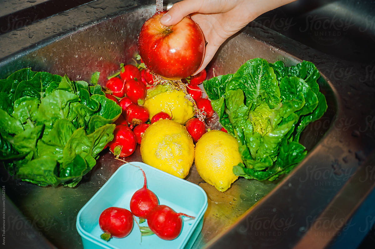Vegetables, greens and fruits washing in the sink