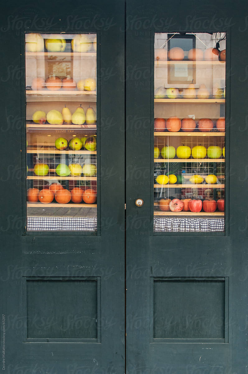 Various fruit on shelves in the windows of a door