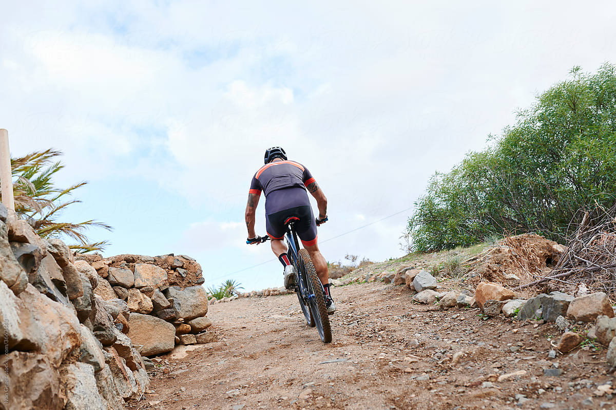 Man mountain biking on a dirt trail