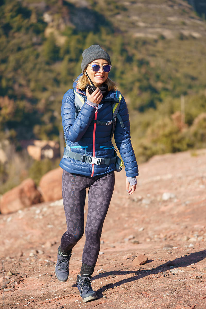 Content active lady with radio set hiking in mountains