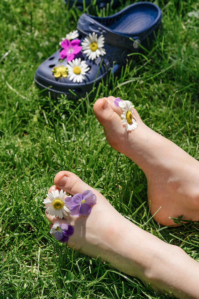 Baby\'s feet with summer meadow flowers.