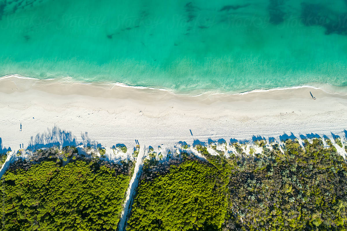 Aerial views over sandy white beaches with blue skies in summer