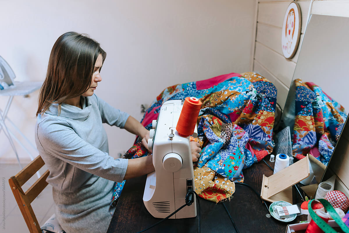 A woman sews in a workshop.