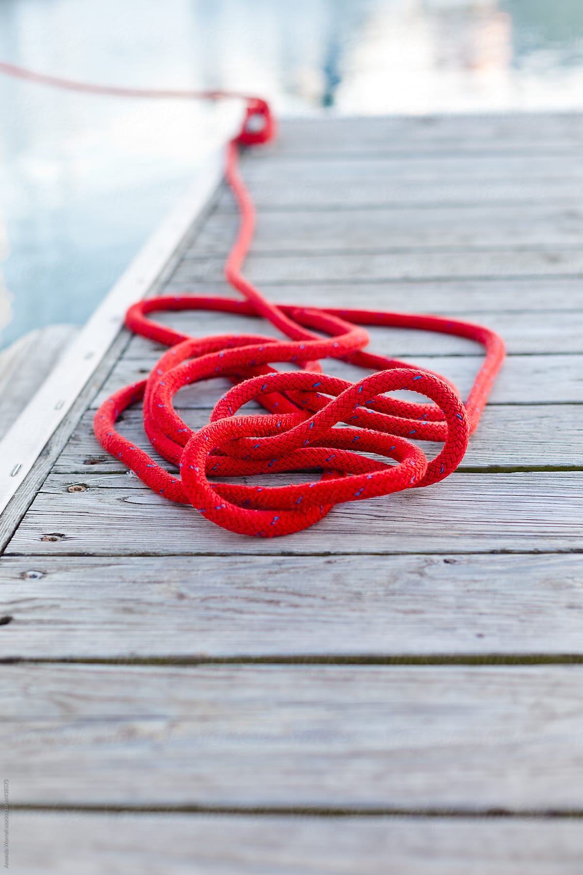 Red rope sits on dock in a loose pile