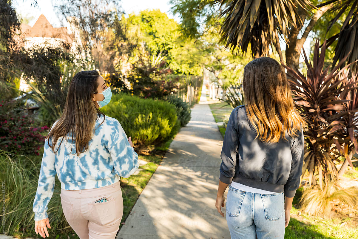 Female Friends Talk 6 Feet Apart Outdoors While Walking
