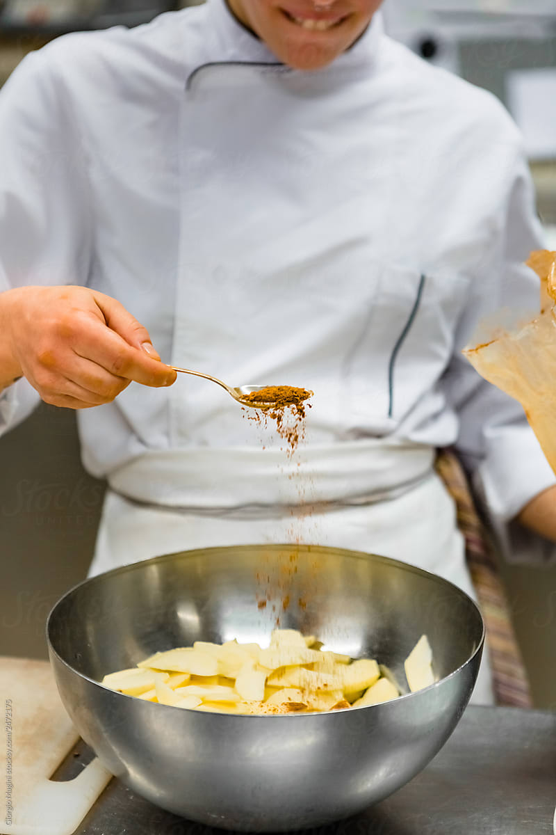 Young Pastry Chef Pouring Cinnamon on Cutted Apples