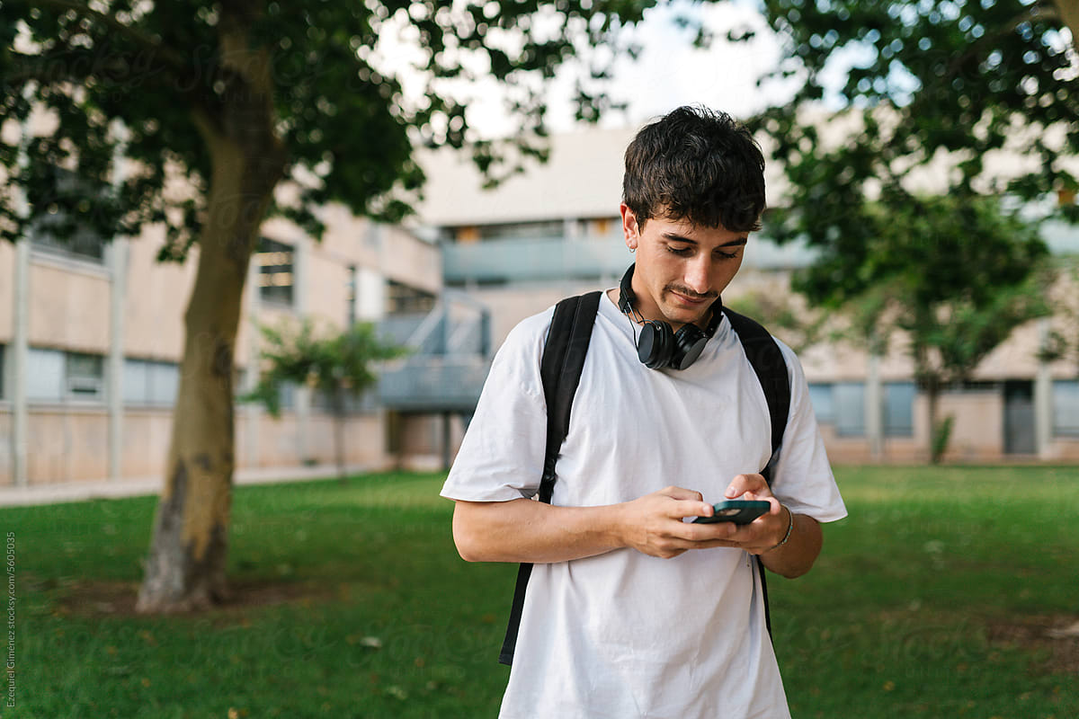 Young man browsing smartphone in park