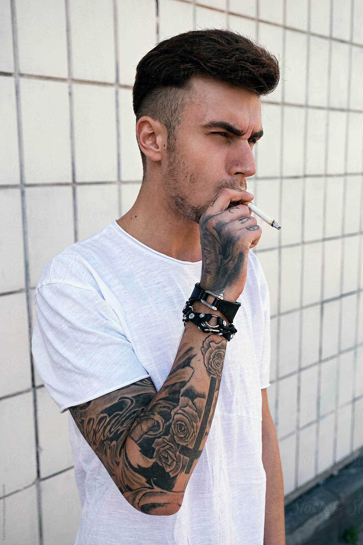 Serious Bearded Man With Tattooed Arms Smoking Cigarette