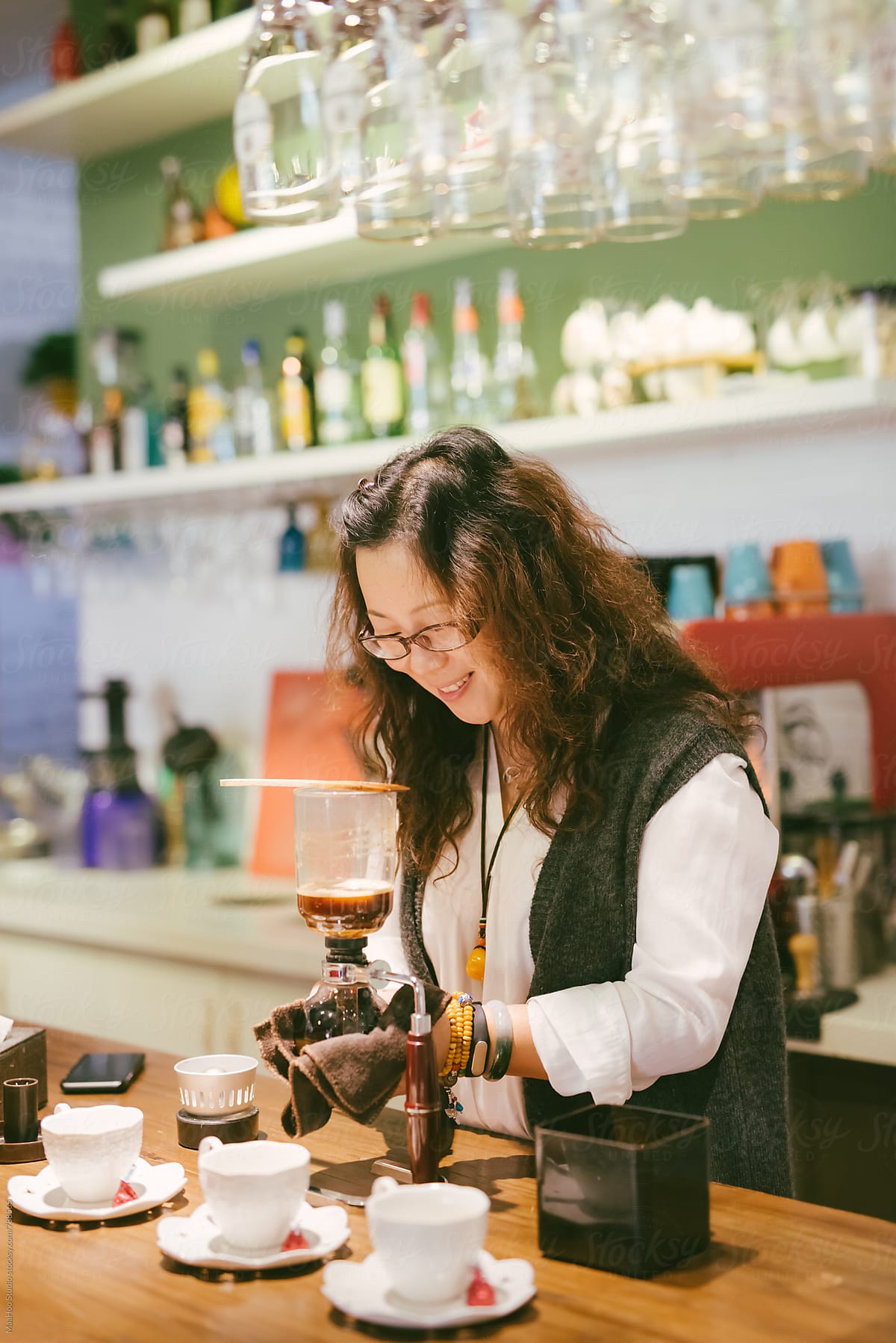 Female coffee shop owner preparing coffee at counter