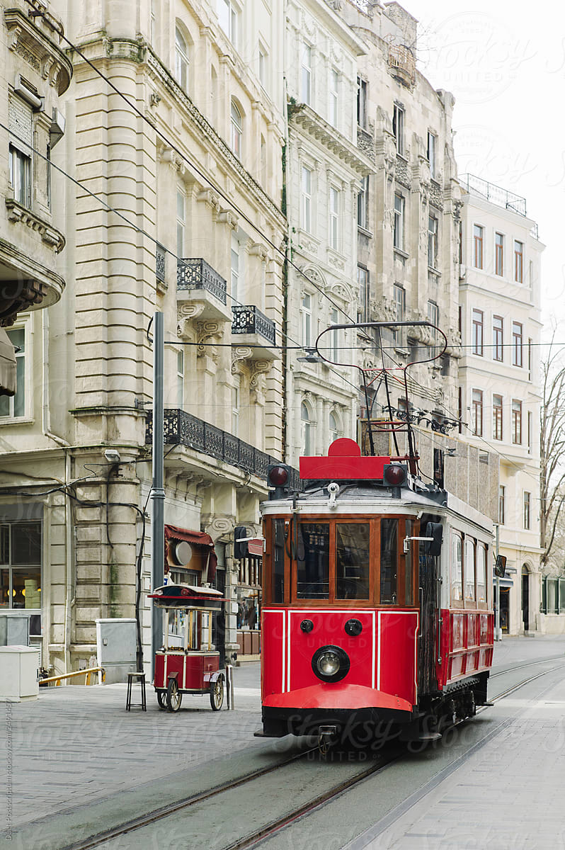 Tram driving on street between vintage buildings