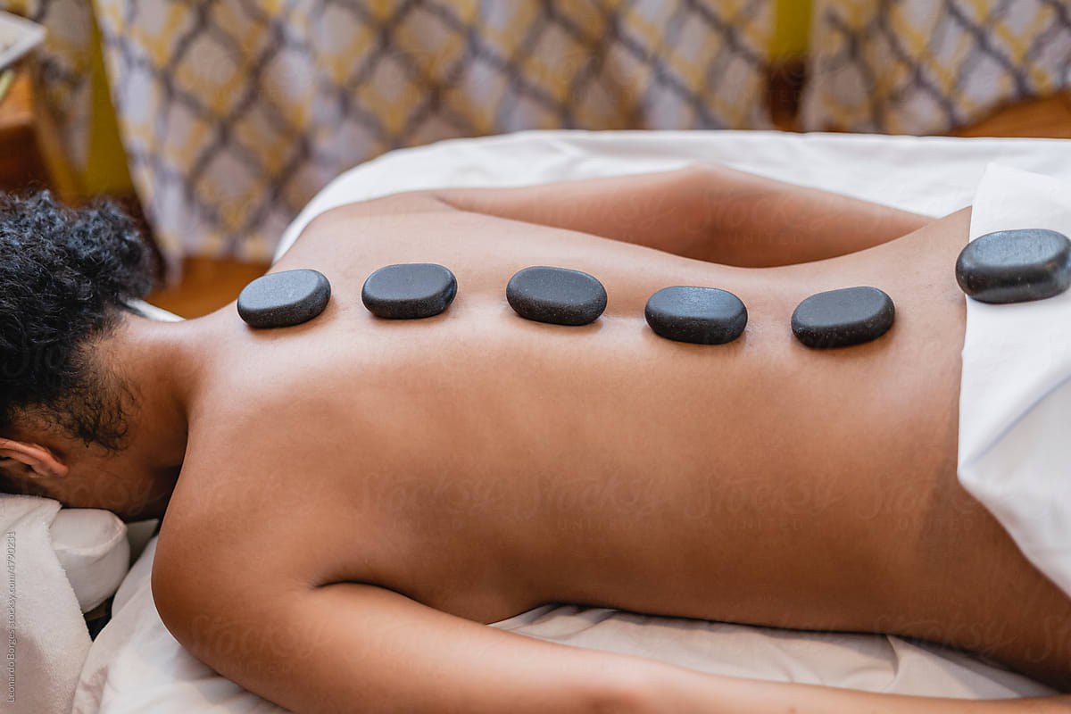 Woman with volcanic stones on her back in a spa.