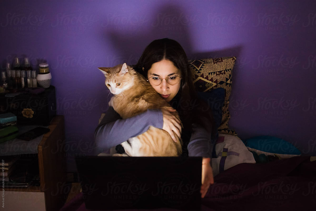 Woman watching streaming tv at nigh with cat