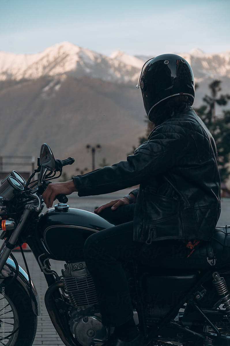 Male biker admiring snowy mountains